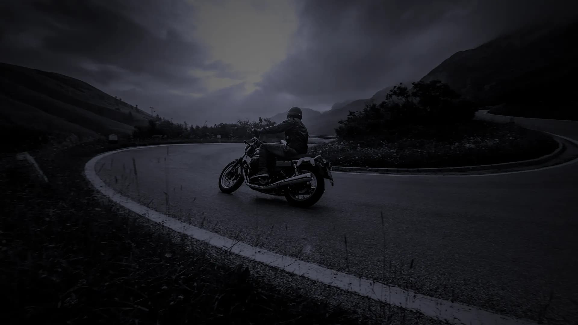 Moto dans un virage en montagne en noir et blanc